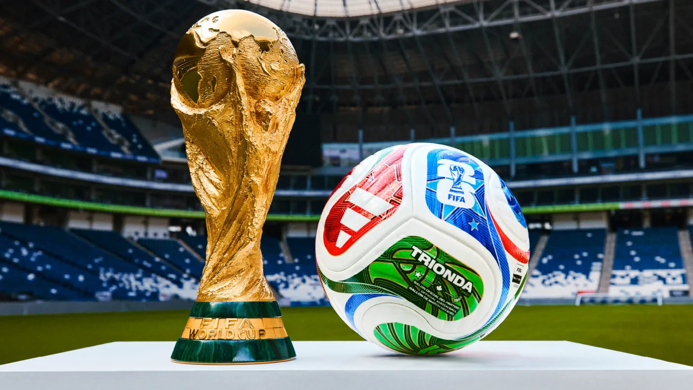 Taça da Copa do Mundo ao lado da bola oficial em um estádio